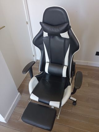 Silla gaming negra y blanca con reposapiés