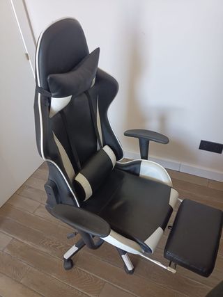 Silla gaming negra y blanca con reposapiés