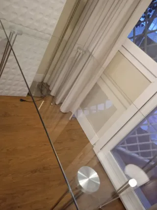 Mesa de cristal con patas metálicas.