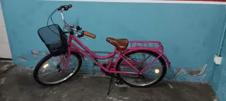 Bicicleta rosa con cesta y portabultos