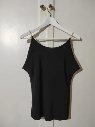 Camiseta negra cadena dorada hombros descubiertos