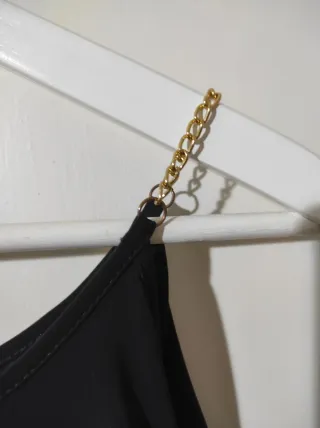 Camiseta negra cadena dorada hombros descubiertos