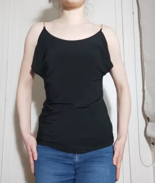 Camiseta negra cadena dorada hombros descubiertos