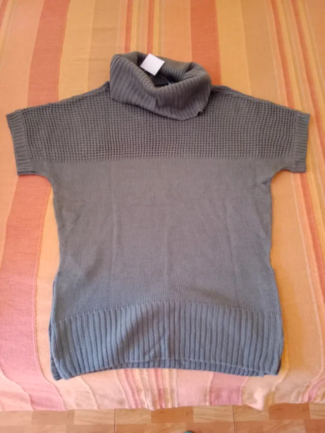 Jersey gris cuello alto.
