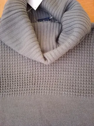 Jersey gris cuello alto.