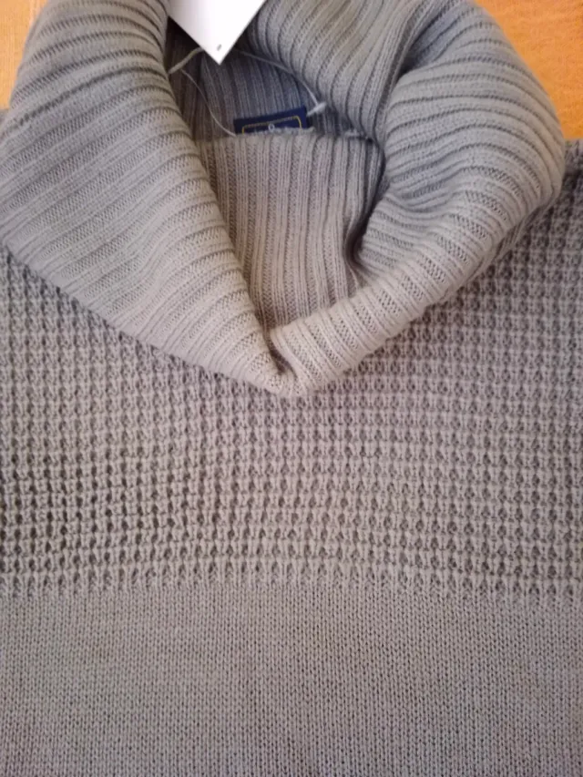 Jersey gris cuello alto.