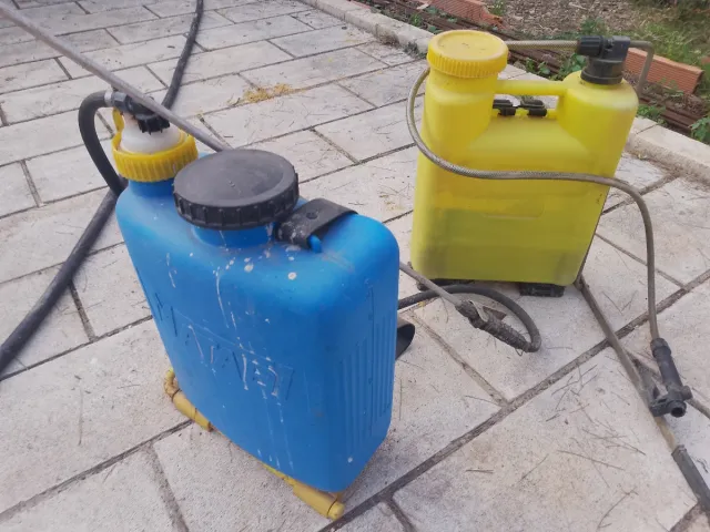 Due zaini per irrorazione, uno blu e uno giallo