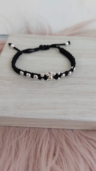 Pulsera negra con detalles plateados