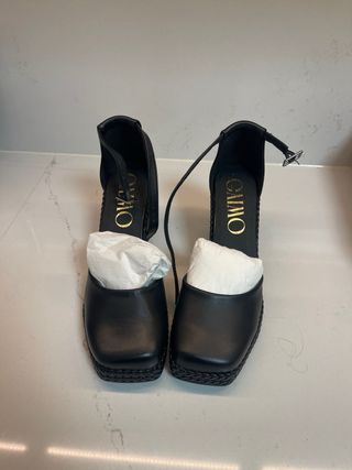 Zapatos de piel negros con pulsera al tobillo.