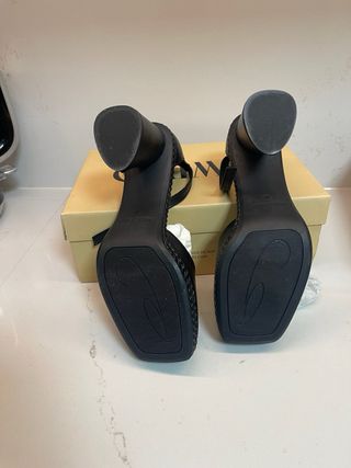 Zapatos de piel negros con pulsera al tobillo.