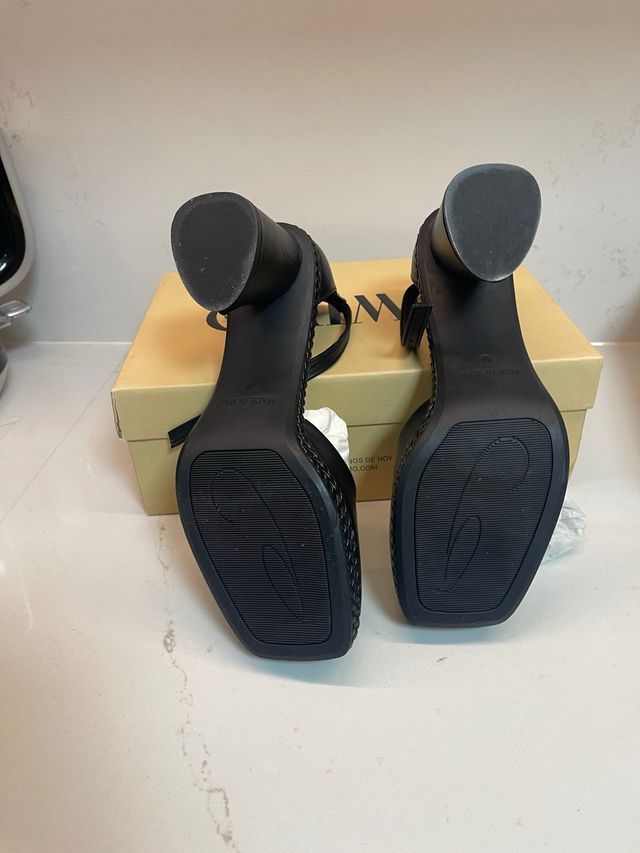 Zapatos de piel negros con pulsera al tobillo.