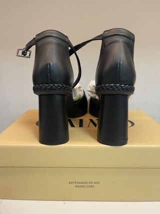 Zapatos de piel negros con pulsera al tobillo.