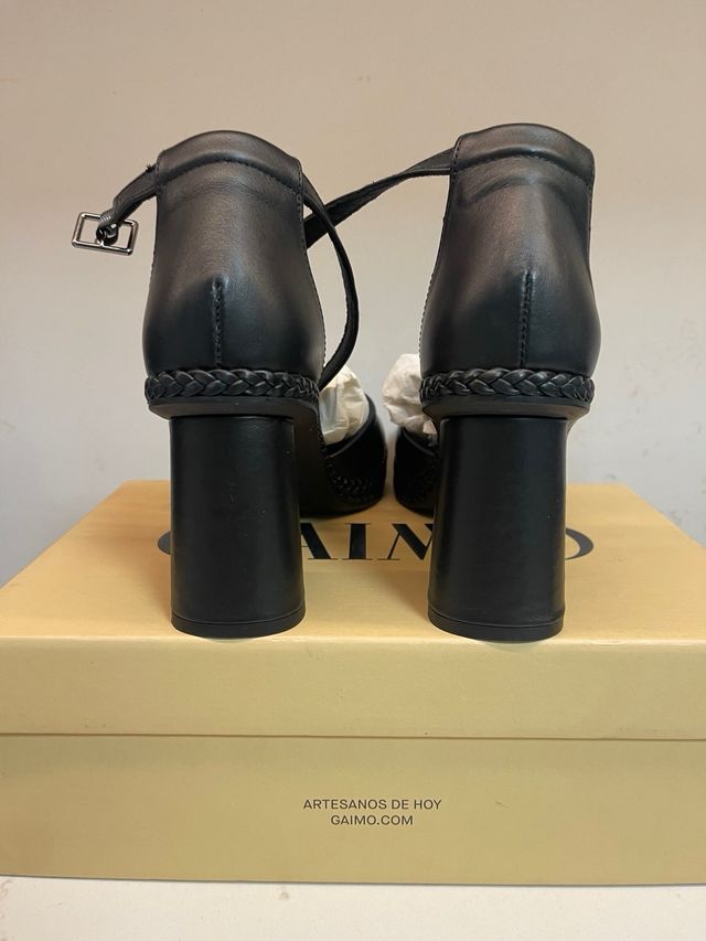 Zapatos de piel negros con pulsera al tobillo.