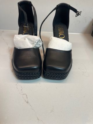 Zapatos de piel negros con pulsera al tobillo.