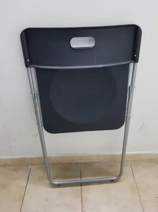 Silla plegable negra y plateada.
