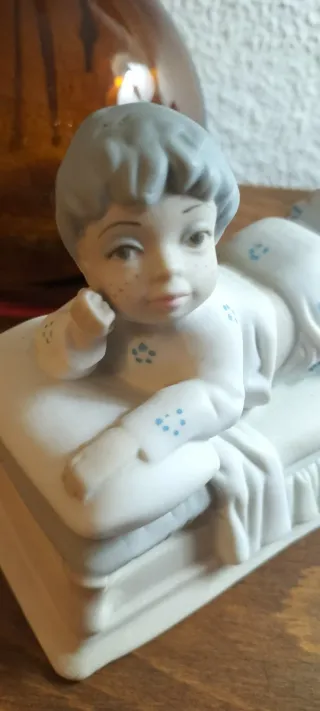 Figurita de porcelana niño tumbado