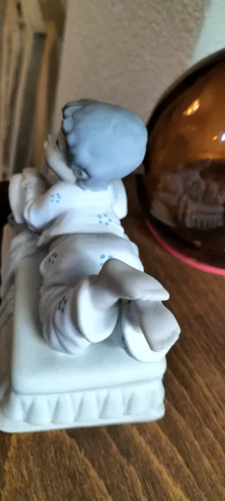 Figurita de porcelana niño tumbado