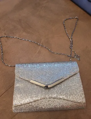 Bolso de fiesta plateado con cadena.