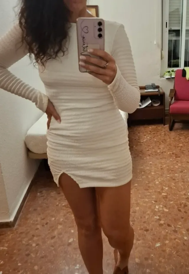Vestido blanco ajustado con abertura.