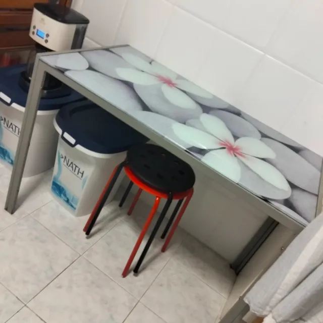 Mesa de cristal y metal con flores