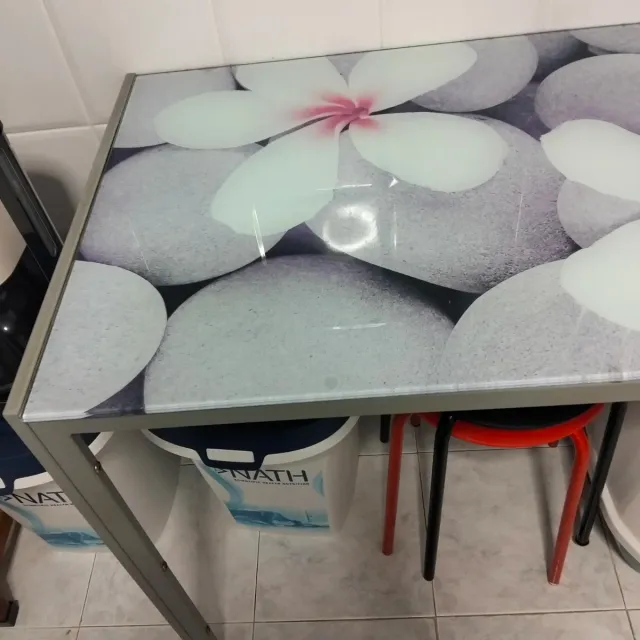 Mesa de cristal y metal con flores