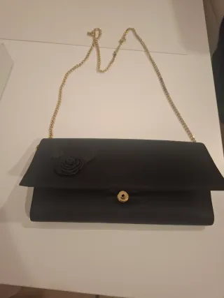 Bolso de mano negro con cadena dorada