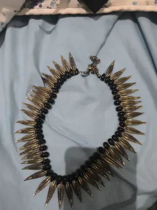 Collar único con plumas doradas y cuentas negras