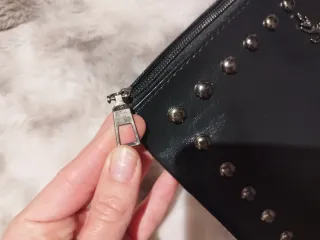 Cartera de mano negra con tachuelas