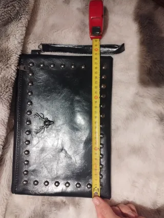 Cartera de mano negra con tachuelas