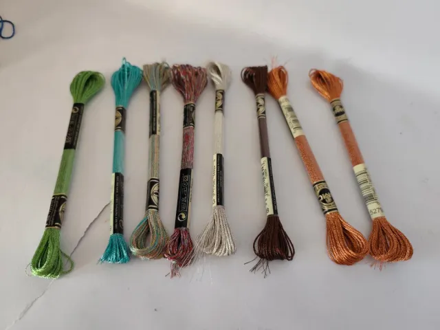 Caja con 56 hilos de bordar nuevos.