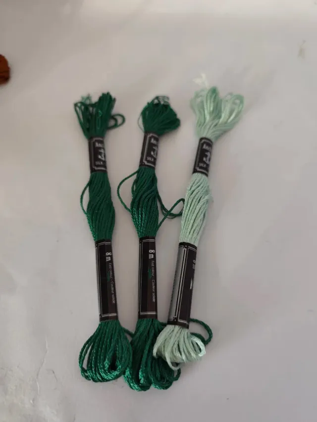 Caja con 56 hilos de bordar nuevos.