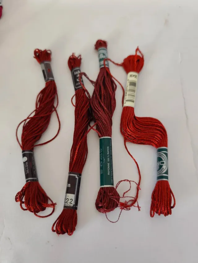 Caja con 56 hilos de bordar nuevos.