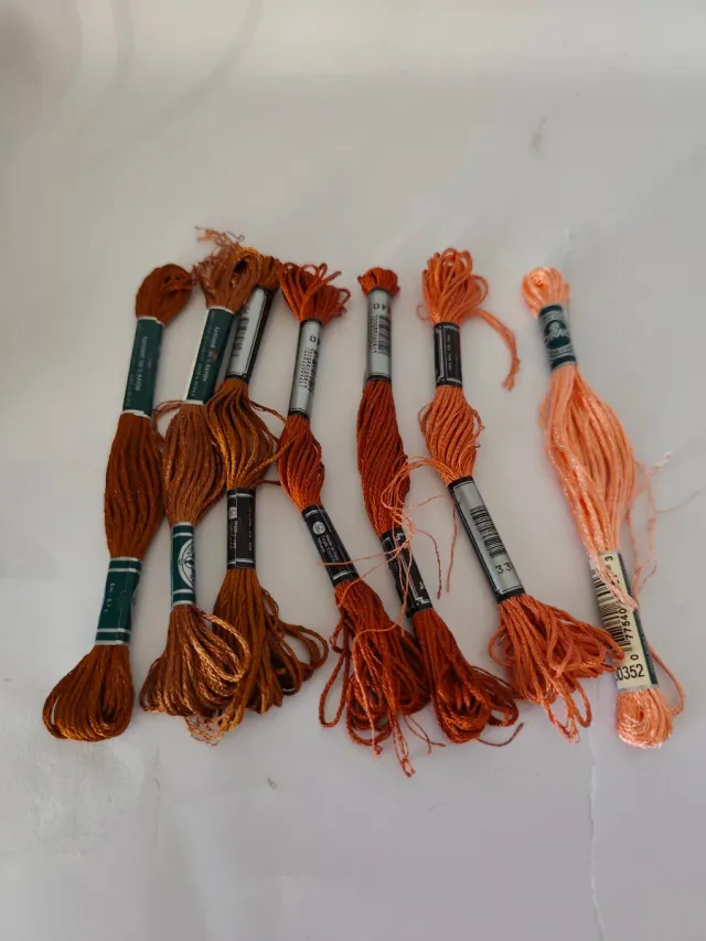 Caja con 56 hilos de bordar nuevos.