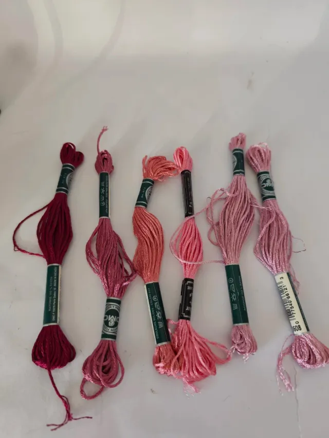 Caja con 56 hilos de bordar nuevos.