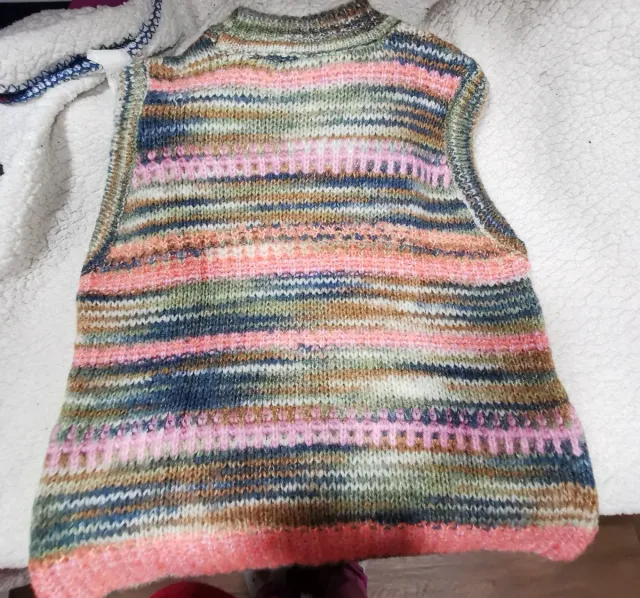 Giubbotto a maglia con design a righe multicolor. Comodo e versatile. Collo tondo e tessuto morbido.