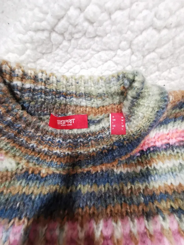 Giubbotto a maglia con design a righe multicolor. Comodo e versatile. Collo tondo e tessuto morbido.