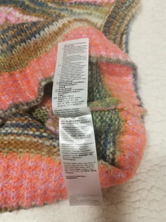 Giubbotto a maglia con design a righe multicolor. Comodo e versatile. Collo tondo e tessuto morbido.