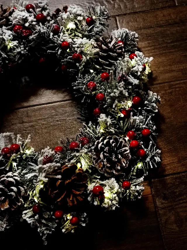 Ghirlanda luminosa con pigne e bacche