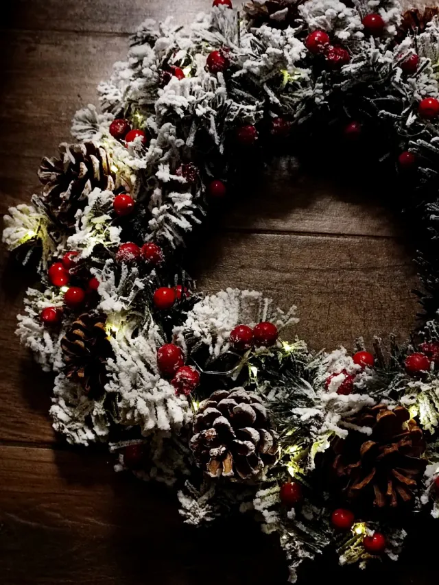 Ghirlanda luminosa con pigne e bacche