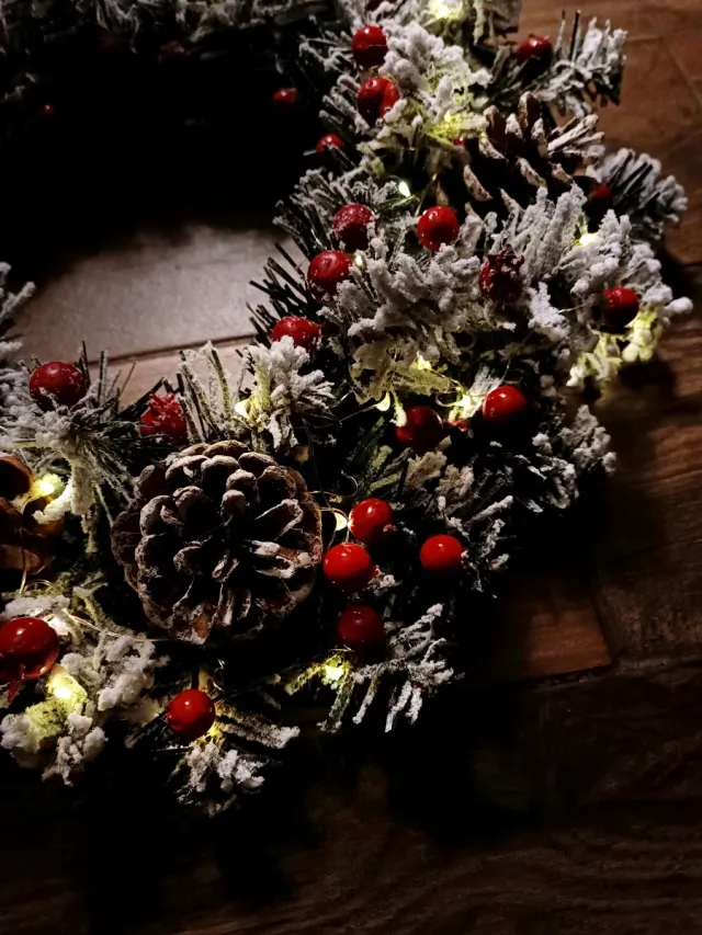 Ghirlanda luminosa con pigne e bacche