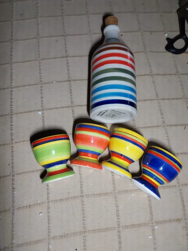 Set di ceramica a righe multicolor con bottiglia e quattro uova
