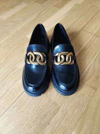 Mocasines negros con detalle dorado