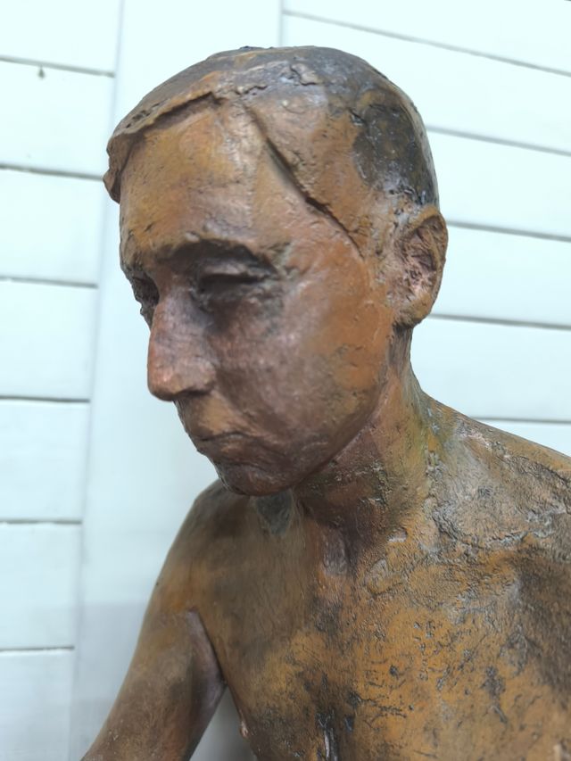 Escultura de hombre firmada.