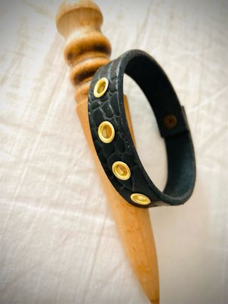 Pulsera cuero negro con ojales dorados