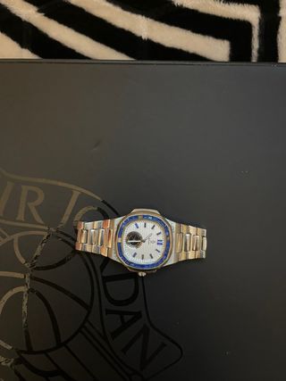 Reloj plateado con detalles azules