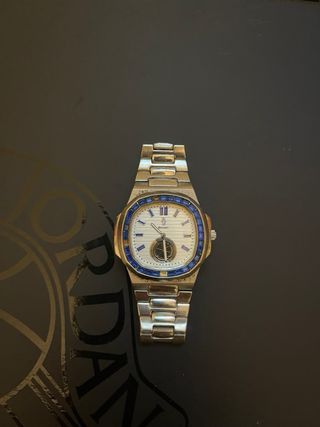 Reloj plateado con detalles azules