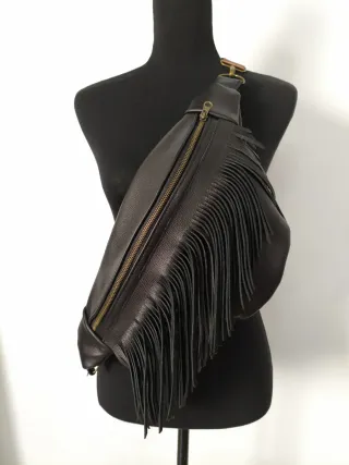 Bolso riñonera piel de color negro. Con flecos