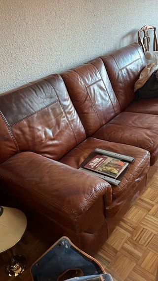 Sofá de cuero marrón con mancha en respaldo