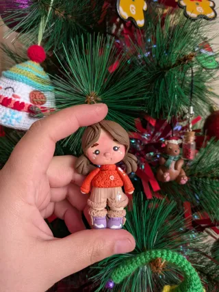 Adorno navideño figura niña jersey naranja