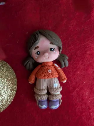 Adorno navideño figura niña jersey naranja